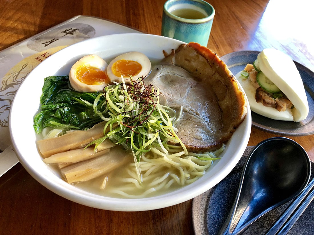 A steaming bowl of Kizuki yuzu shio ramen topped with chashu pork, soft-boiled egg, and fresh scallions